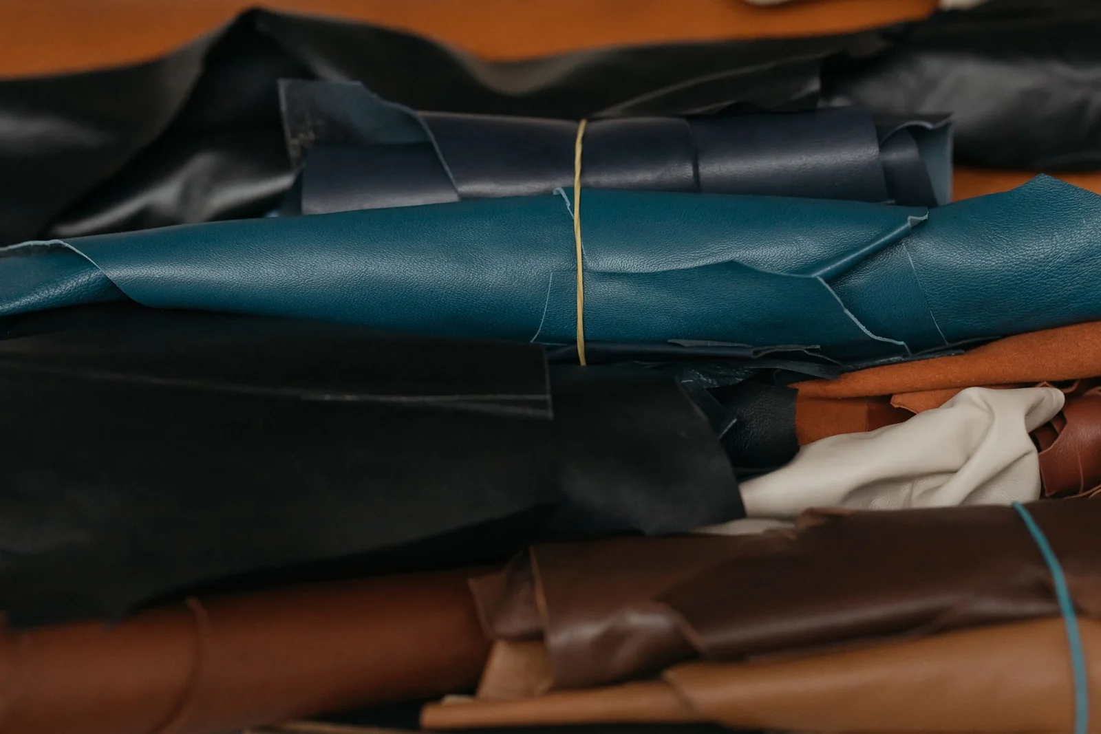 Richly textured leather rolls in a range of tones, an illustration of the company's leather category